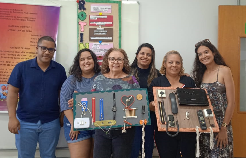 Professora Alciane Macedo com alunas do curso de Pedagogia Bilíngue (atualmente no 6º período) e intérprete de Libras do IFG Aparecida, apresentando painéis interativos produzidos pela turma e entregues em escolas campos de estágio Professora Alciane Macedo com alunas do curso de Pedagogia Bilíngue (atualmente no 6º período) e intérprete de Libras do IFG Aparecida, apresentando painéis interativos produzidos pela turma e entregues em escolas campos de estágio